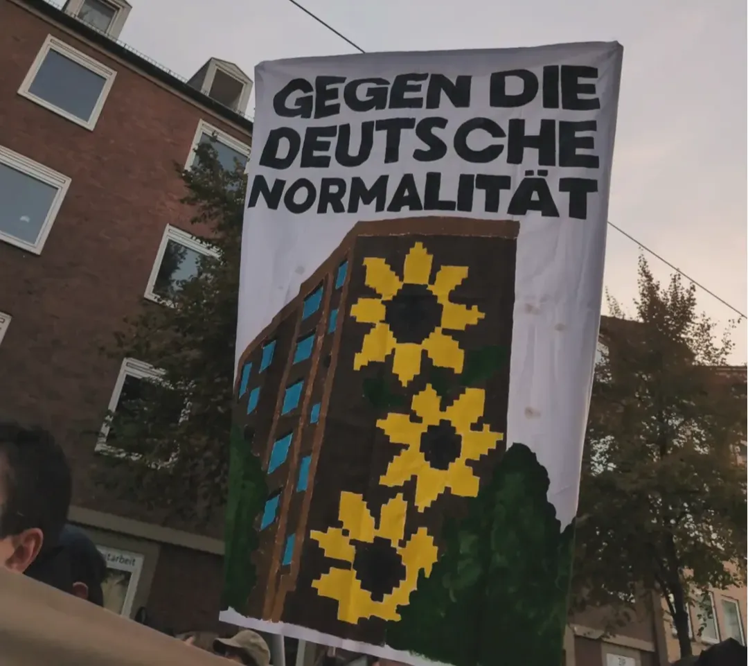 Hochbanner Gegen die deutsche Normalität. Zeichnung des Sonnenblumenhauses.