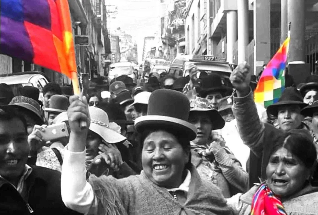 Foto aus Bolivien, schwarz Wwiß, Frauen mit Hüten und buten Fahnen