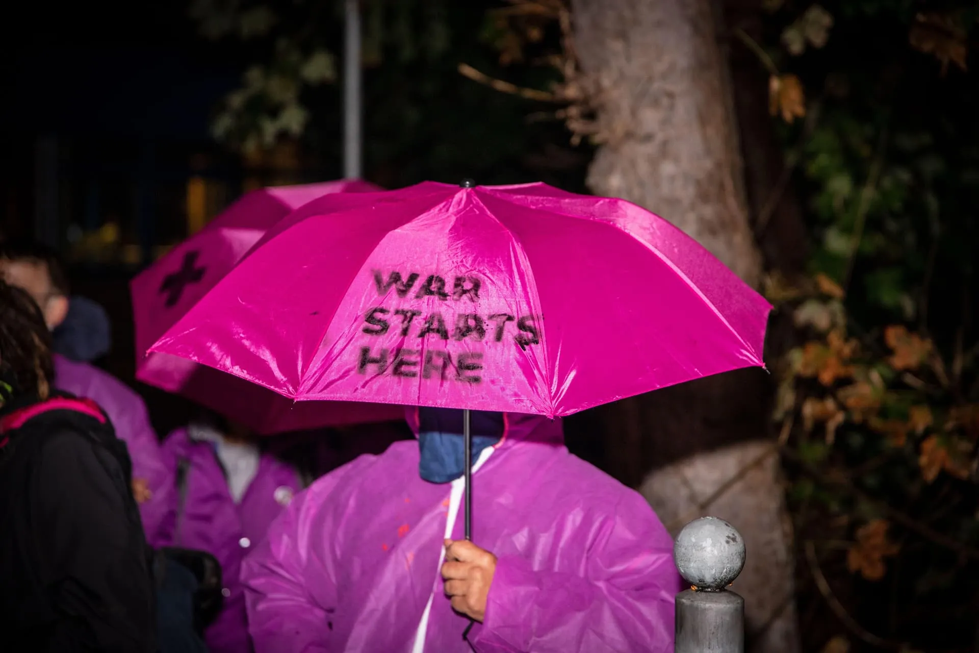 pinker Regenschirm mit der Aufschrift War starts here