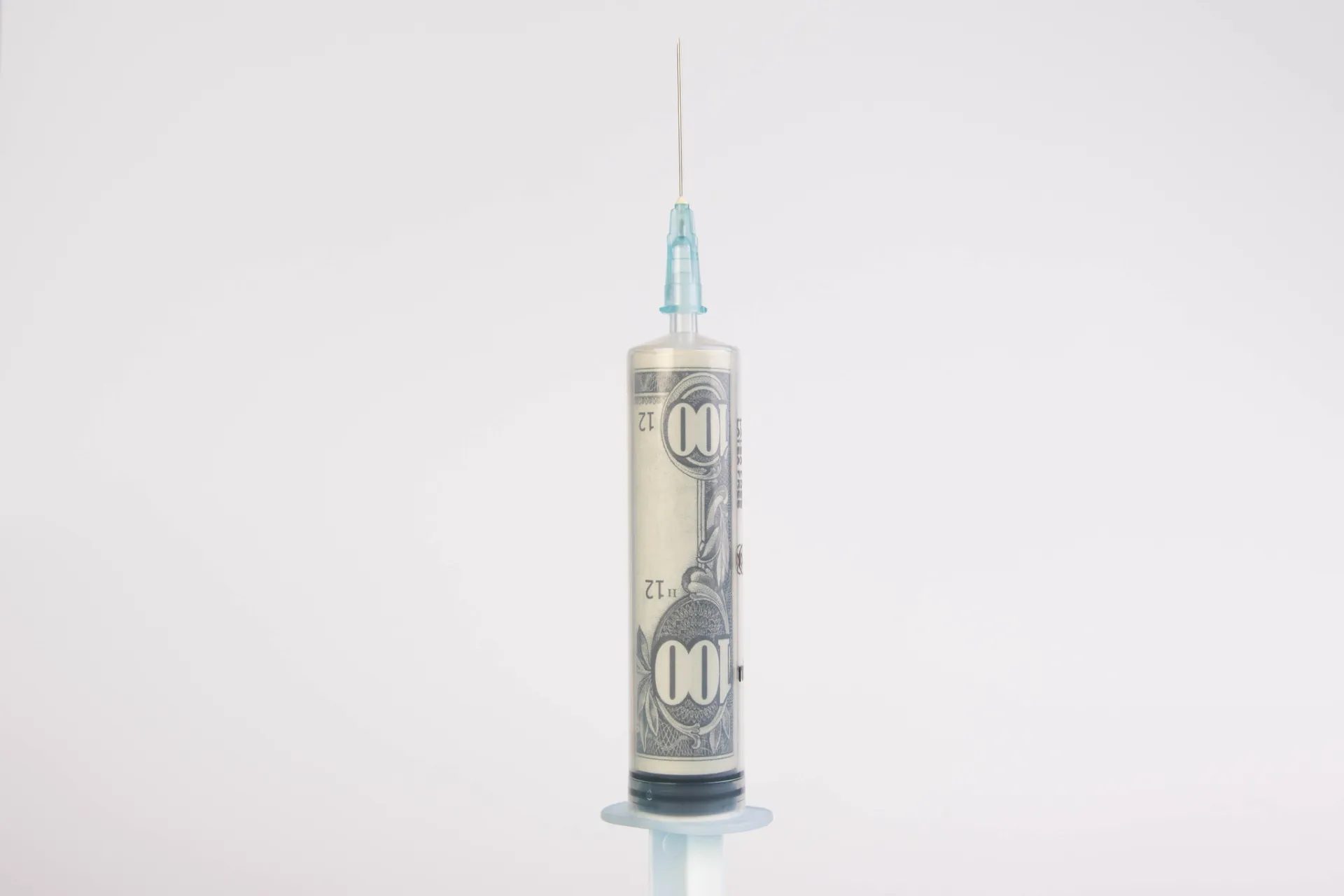 eine Spritze, aufgezogen mit einem 100 Dollar Schein