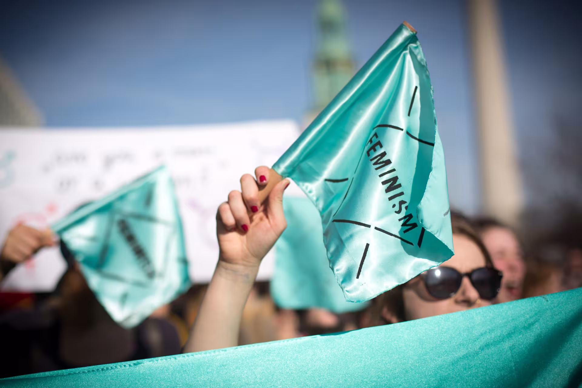 türkise Fahne mit der Aufschrift "Feminism"