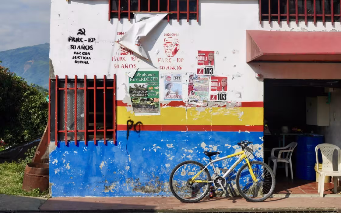 Fahrrad vor einer bunten Hauswand mit abgerissenen und verblichenen Protestplakaten