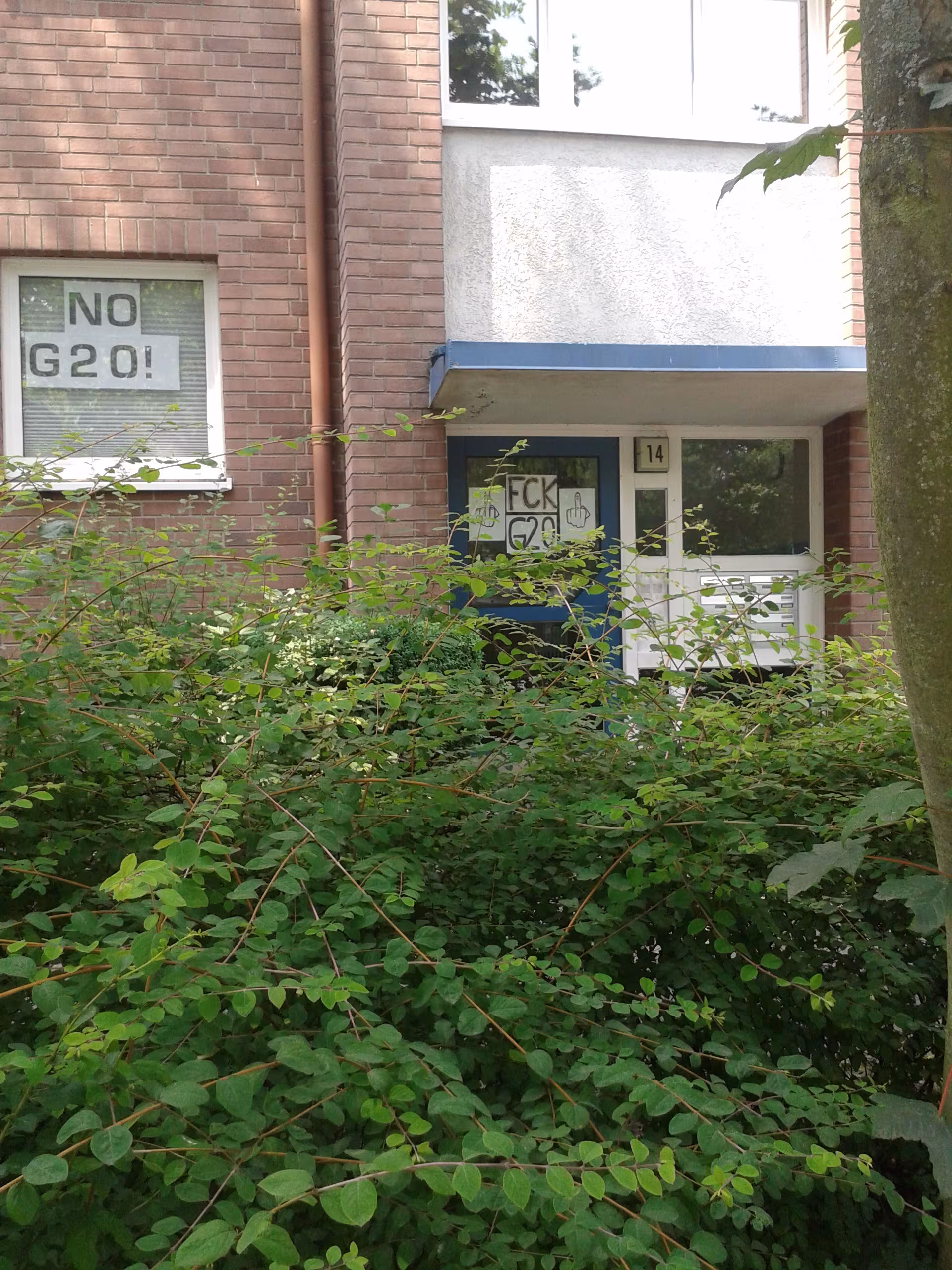 No G20 und Fuck G20 im Fenster und der Tür eines Wohnhauses
