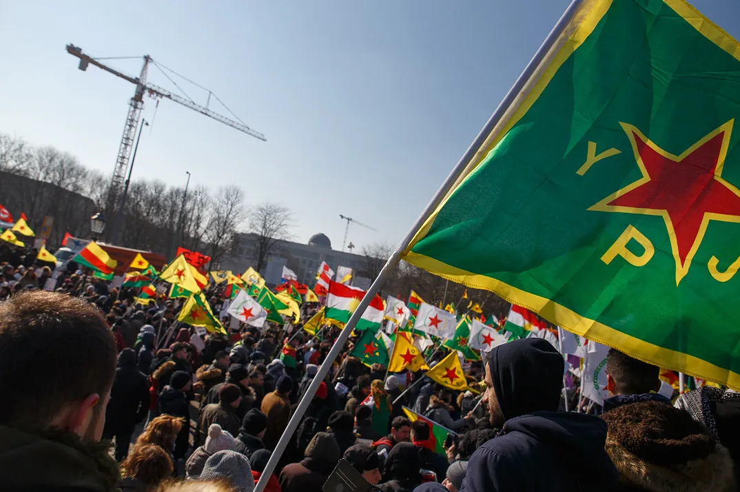 viele Menschen, die YPG/YPJ Fahnen schwenken