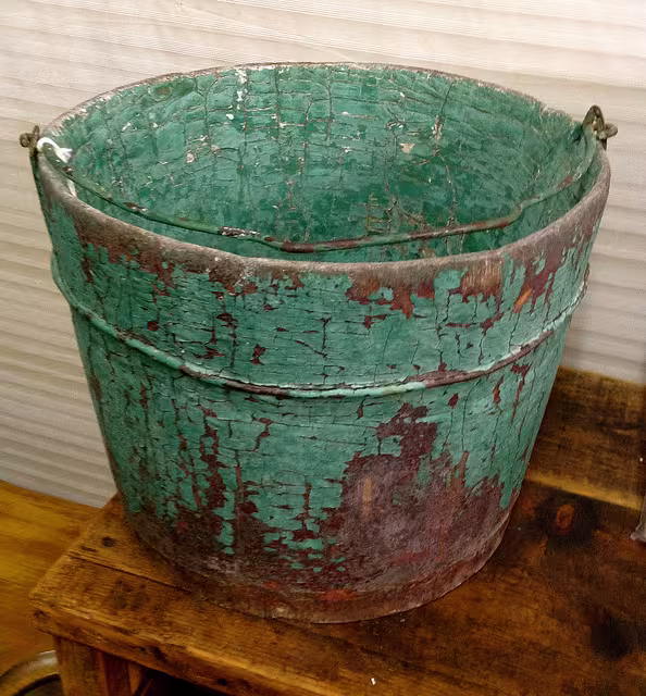 Holzeimer mit abblätternder grüner Farbe