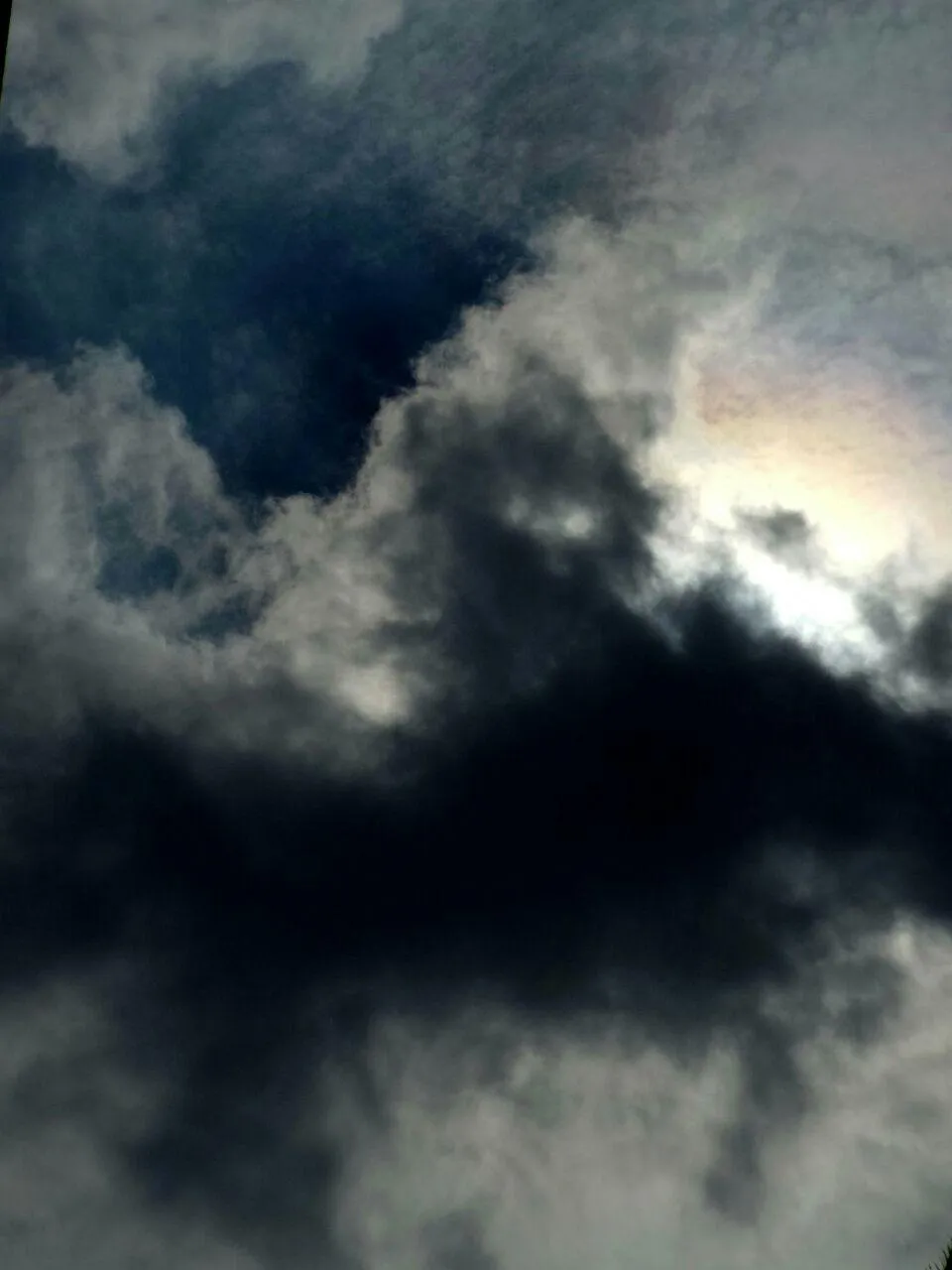 Sonne hinter Wolken, blauer Himmel