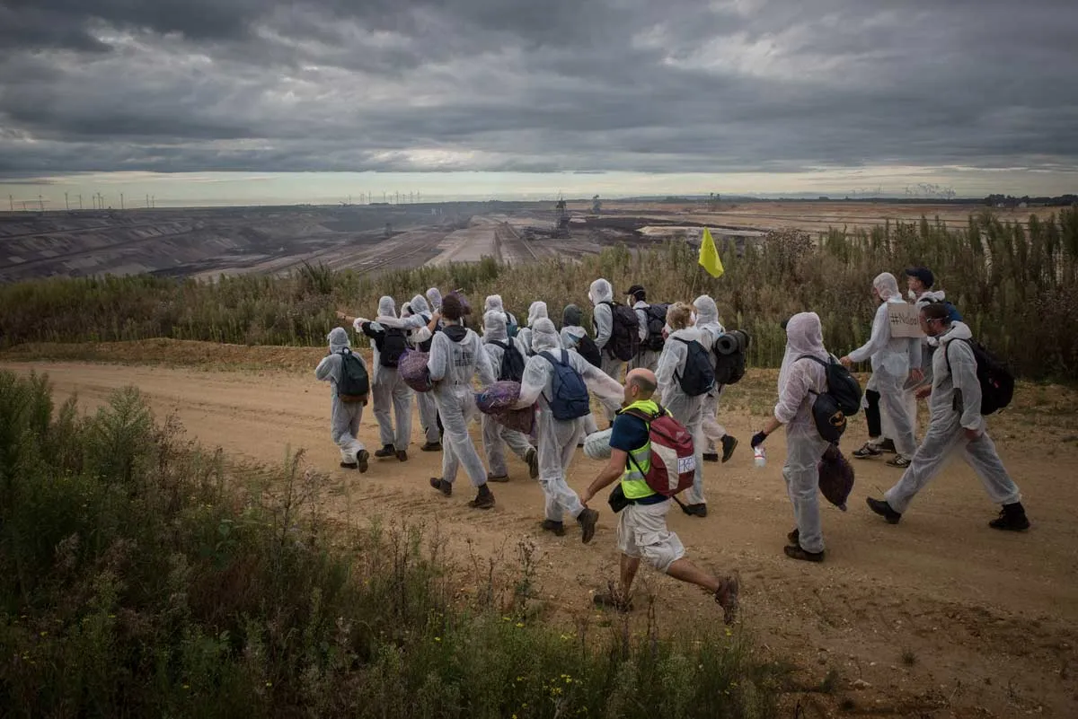 Menschen in Maleranzügen auf dem Weg zur Kohlegrube