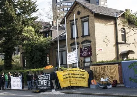 Protestierende Menschen mit Transparenten vor CDU Büro