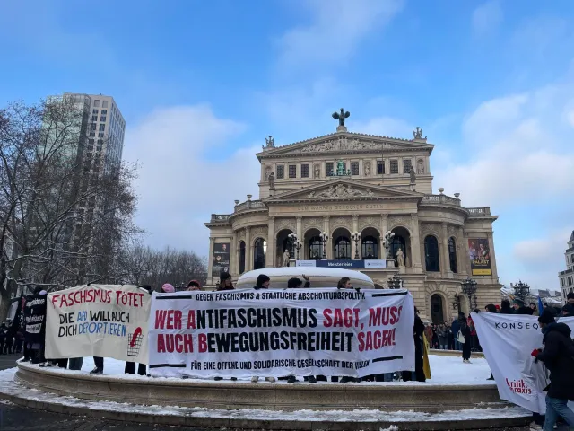 Menschen mit bannern vor historischem Gebäude