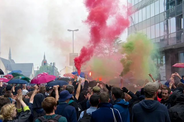 Demonstration bei blockupy bunter rauch und regenschirme in der Menge