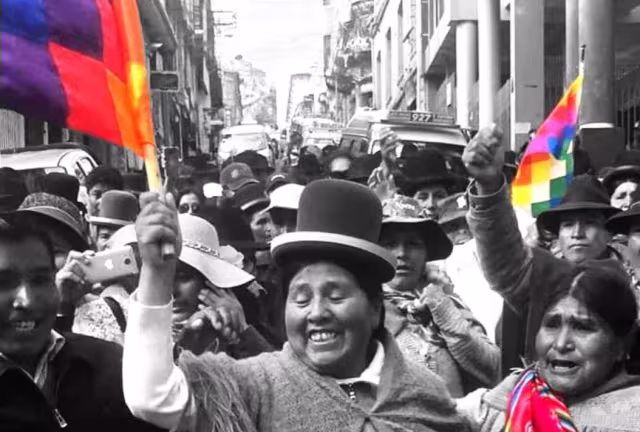 Foto aus Bolivien, schwarz Wwiß, Frauen mit Hüten und buten Fahnen