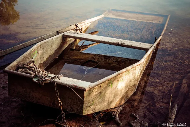 ein mit Wasser voll gelaufenes altes Ruderboot