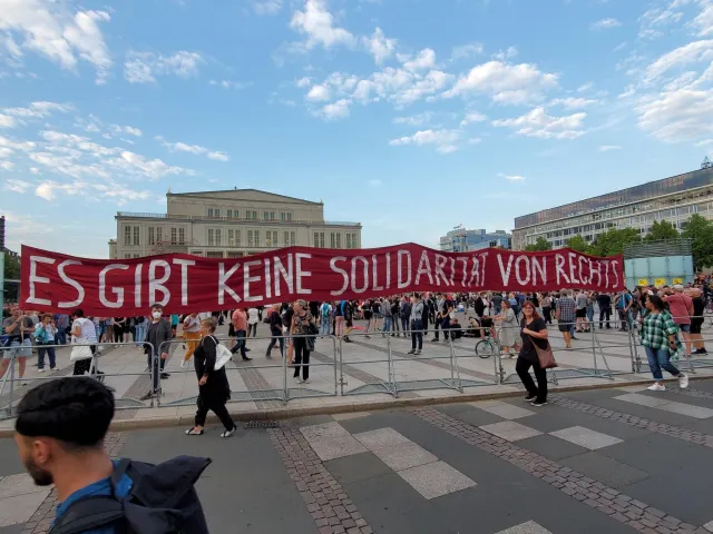 Menschen halten ein langes Banner mit der Aufschrift Es gibt keine Solidarität von rechts