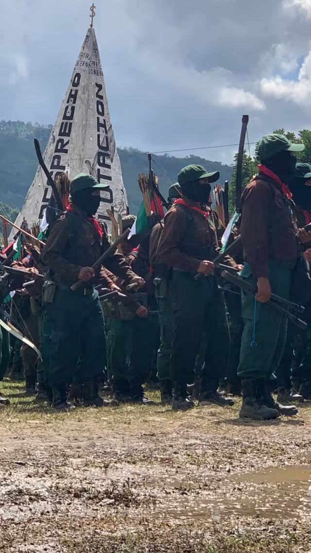 Uniformierte Zapatistas vor einer symbolischen Pyramide