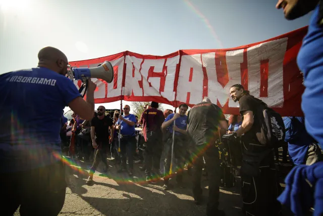 Arbeiter*innen halten ein Banner mit der Aufschrift Insorgiamo