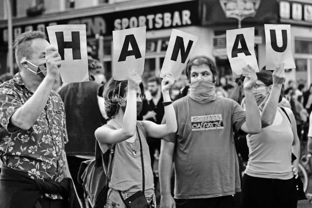 Menschen halten Schilder hoch mit den Buchstaben H A N A U