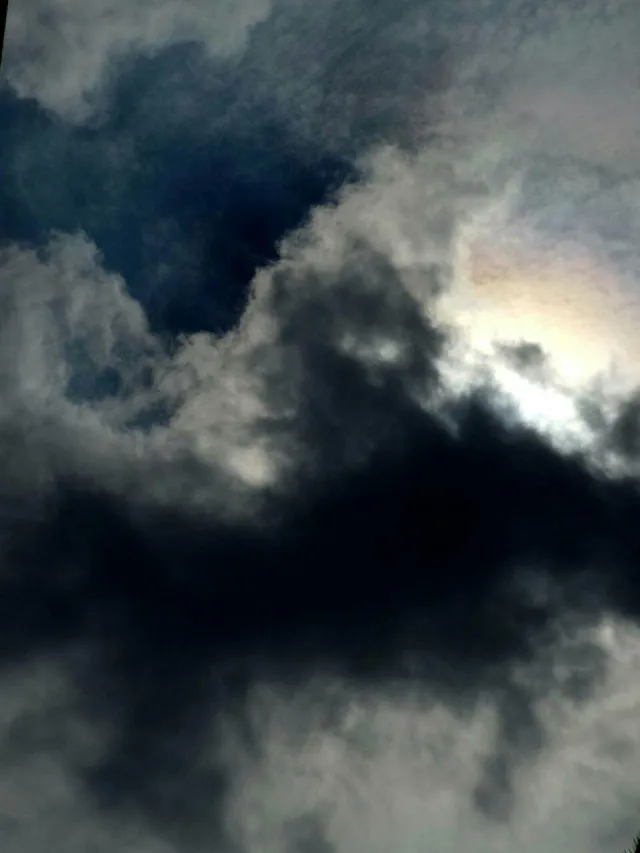 Sonne hinter Wolken, blauer Himmel