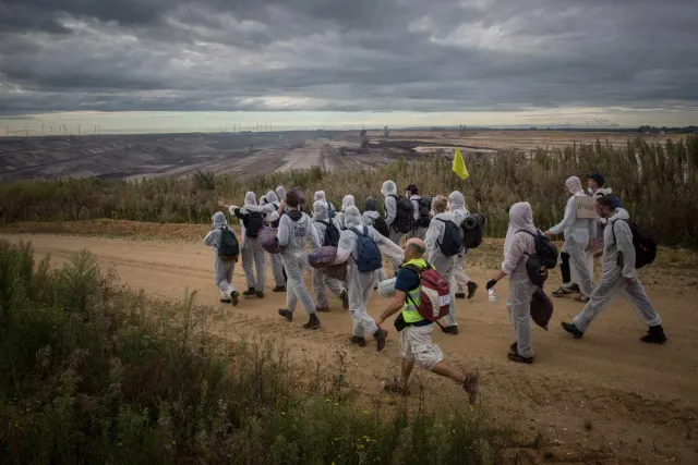 Menschen in Maleranzügen auf dem Weg zur Kohlegrube