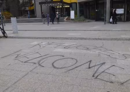 Refugees Welcome Graffiti auf beton Boden