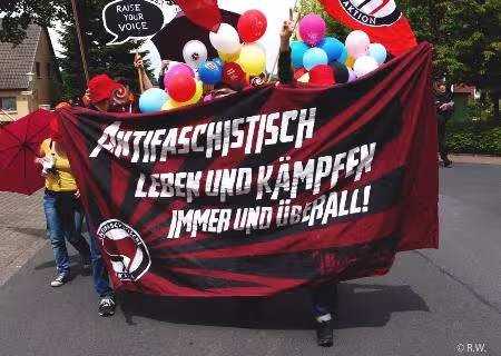 Antifa leben und kämpfen überall - Banner, dahinter Luftballons