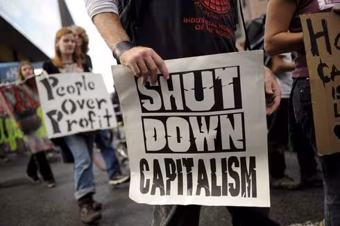 Person halt shut down capitalism schild
