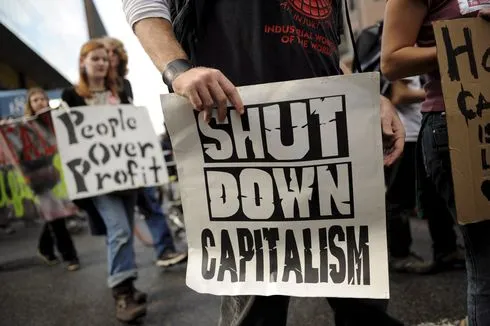Person halt shut down capitalism schild